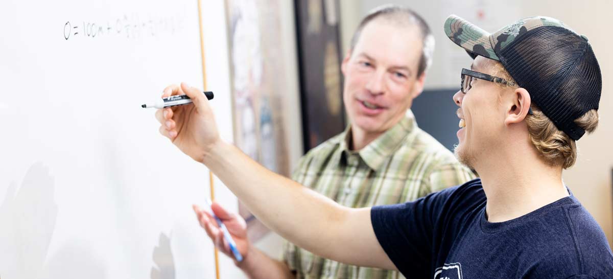 Tutor working with student at white board